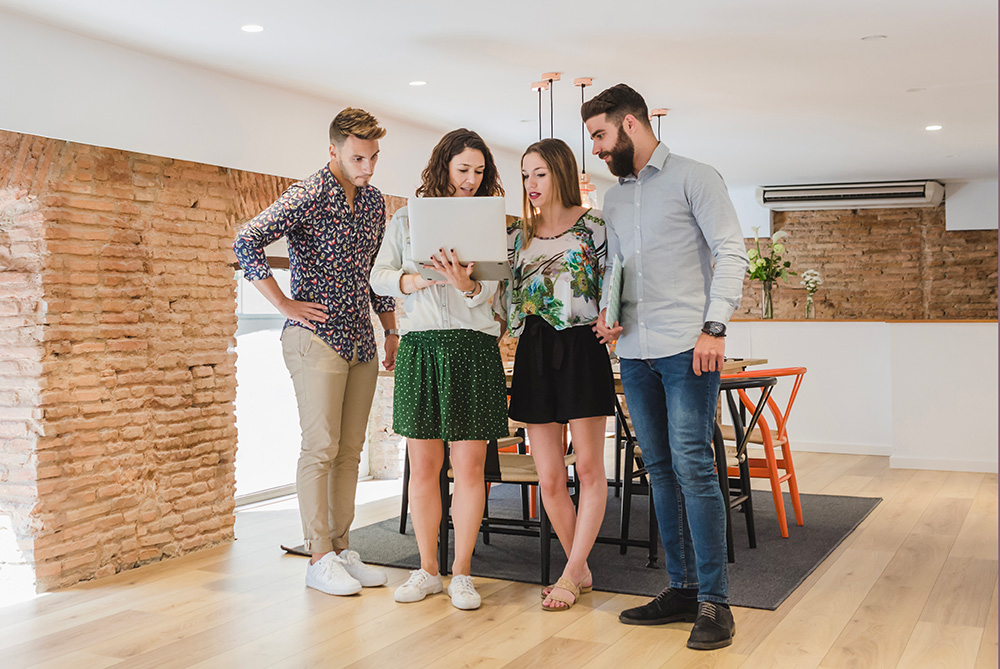 family standing in new home with laptop